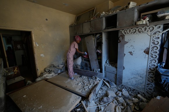 KEYPIX - A domestic worker cleans a damaged bedroom in the southern port city of Tyre, Lebanon, Thursday, April 30, 2026 as the homeowner returns to the house. (KEYSTONE/AP Photo/Hussein Malla)