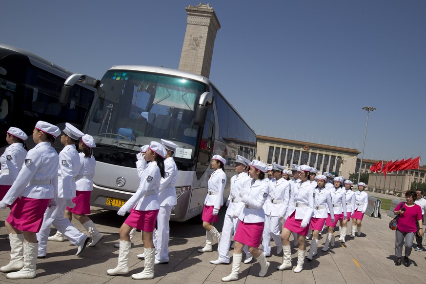 In this May 29, 2014 photo, high school students dressed in uniforms march on Tiananmen Square to stand at guard posts of Young Pioneers, a youth group under the Communist Party of China, around the M ...