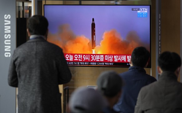 People watch a TV screen showing a news program reporting about North Korea&#039;s missile with file footage, at a train station in Seoul, South Korea, Wednesday, March 16, 2022. North Korea&#039;s la ...