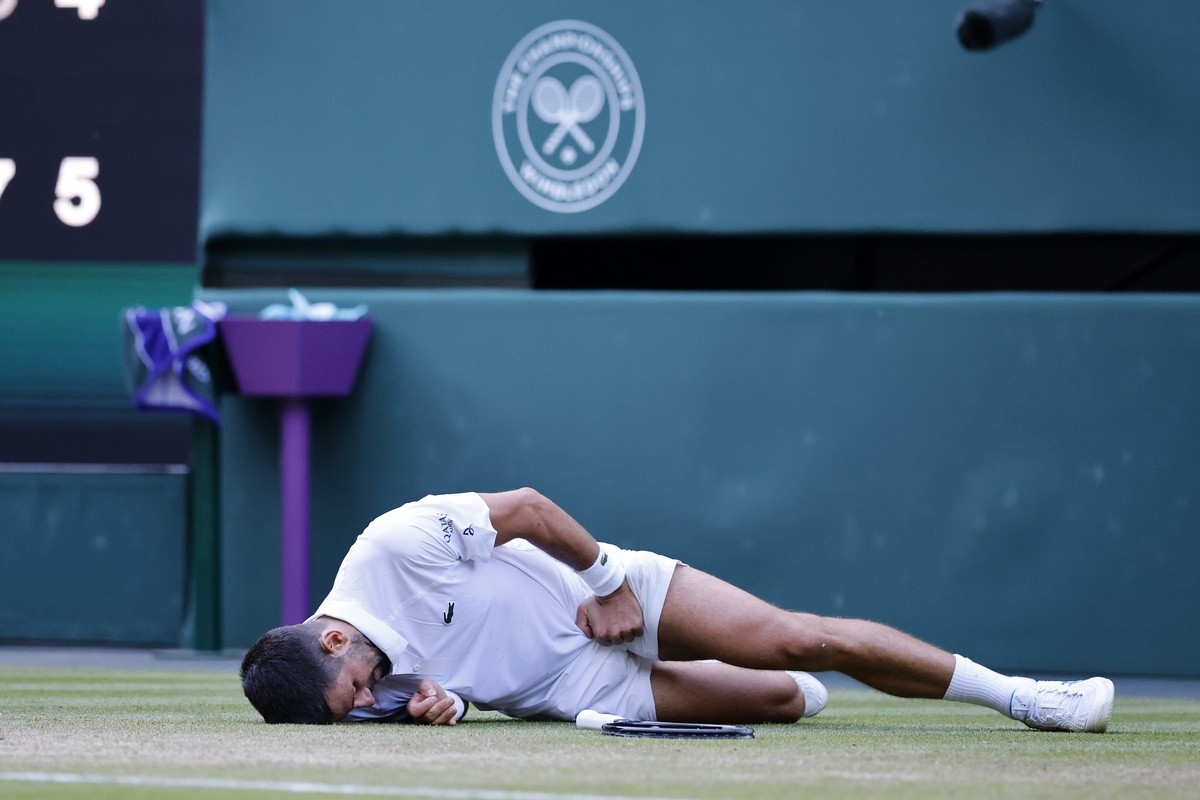 epaselect epa12227765 Novak Djokovic of Serbia falls on the ground during his Men's Singles quarter-finals match against Flavio Cobolli of Italy at the Wimbledon Championships, Wimbledon, Britain ...
