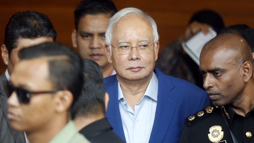 In this May 22, 2018, file photo, former Malaysian Prime Minister Najib Razak, center, arrives at Anti-Corruption Agency for questioning in Putrajaya, Malaysia. Malaysia&#039;s anti-graft agency says  ...