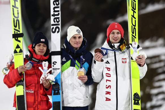 epa12740668 Silver medalist Ren Nikaido of Japan (L), gold medalist Domen Prevc of Slovenia (C) and bronze medalist Kacper Tomasiak of Poland (R) pose for a photo after the Men's Large Hill of th ...