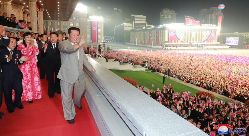 epaselect epa09456635 A photo released by the official North Korean Central News Agency (KCNA) shows North Korean leader Kim Jong-un (front) waving at the crowd during a military parade at Kim Il-sung ...