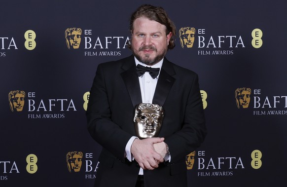 Brady Corbet poses with the award for best director for &quot;The Brutalist&quot; at the 78th British Academy Film Awards, BAFTA&#039;s, in London, Sunday, Feb. 16, 2025. (Photo by Joel C Ryan/Invisio ...