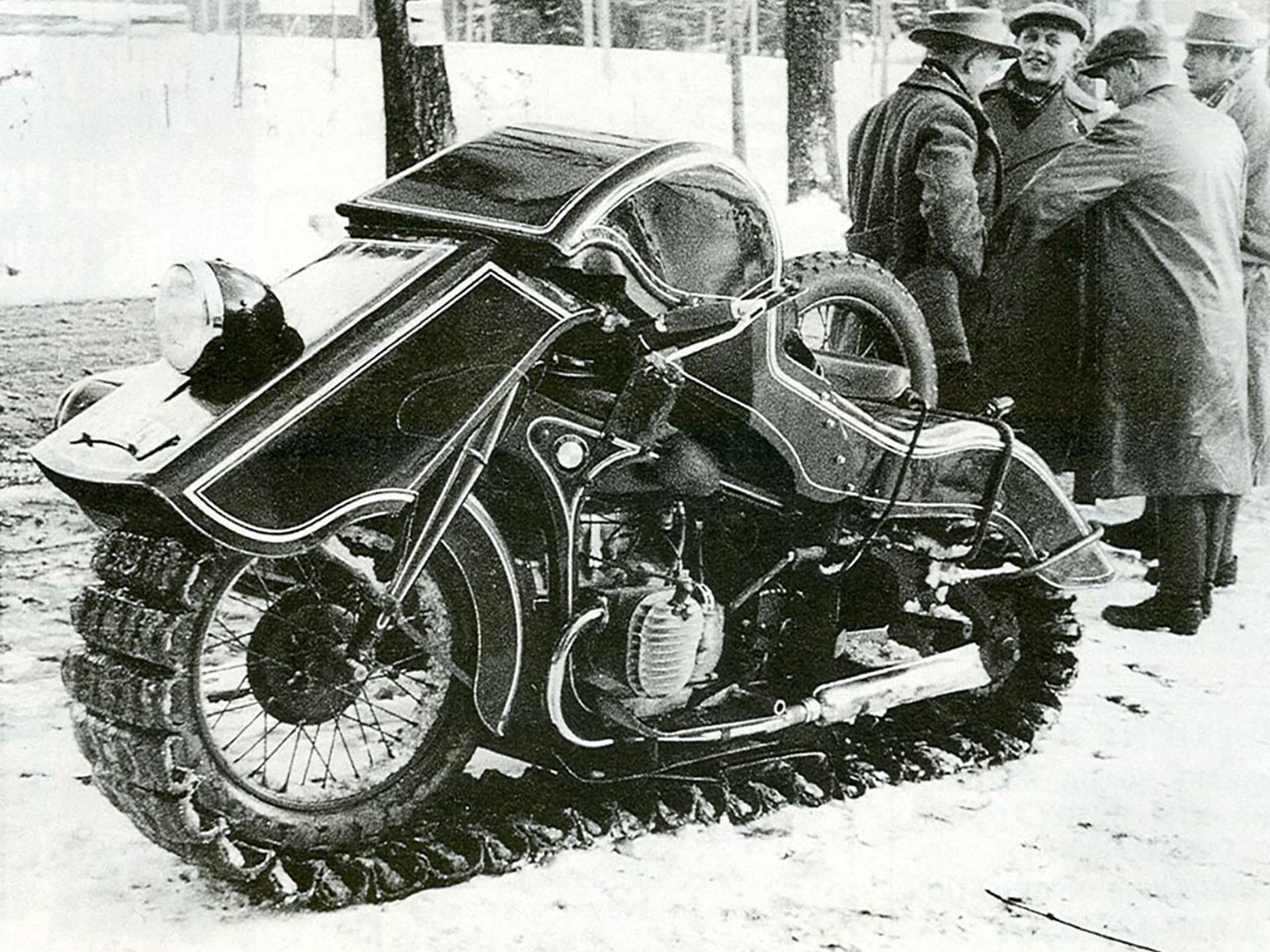 People stand near a BMW Schneekrad which was an all-terrain motorcycle in Germany in 1936.
https://silodrome.com/brutsch-mopetta/