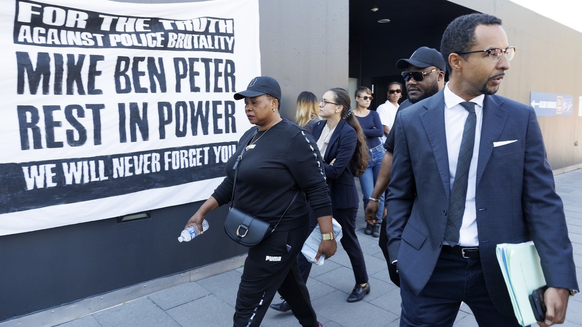 La veuve de Mike Bridget Efe, gauche, le frere de Mike, 2e droite, et Simon Ntah, droite, avocat de la famille de Mike Ben Peter, arrivent pour l'ouverture du proces de six policiers accuses de l ...