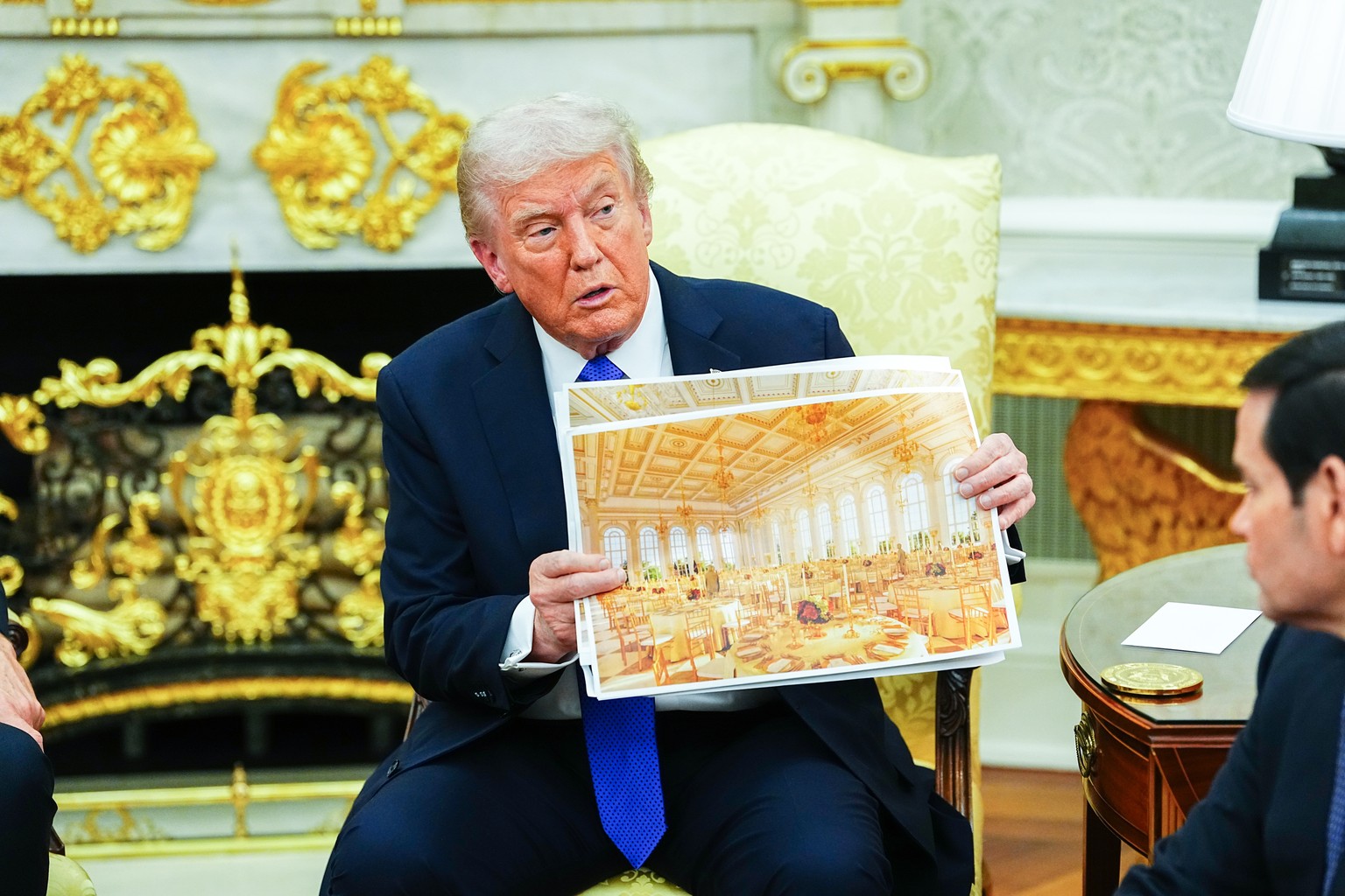 epa12474294 United States President Donald J. Trump shows an interior rendering of the new White House Ballroom as he meets with NATO Secretary General Mark Rutte in the Oval Office of the White House ...