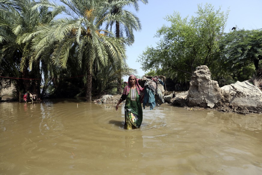 A woman wades through a flooded area after heavy rains in the Shikarpur district of Sindh province, Pakistan, Tuesday, Aug. 30, 2022. Disaster officials say nearly a half million people in Pakistan ar ...