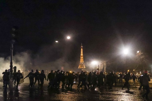 epa10527538 Police officers run during a demonstration near the National Assembly after the French National Assembly vote on the government&#039;s proposed pension reform law, in Paris, France, 16 Mar ...