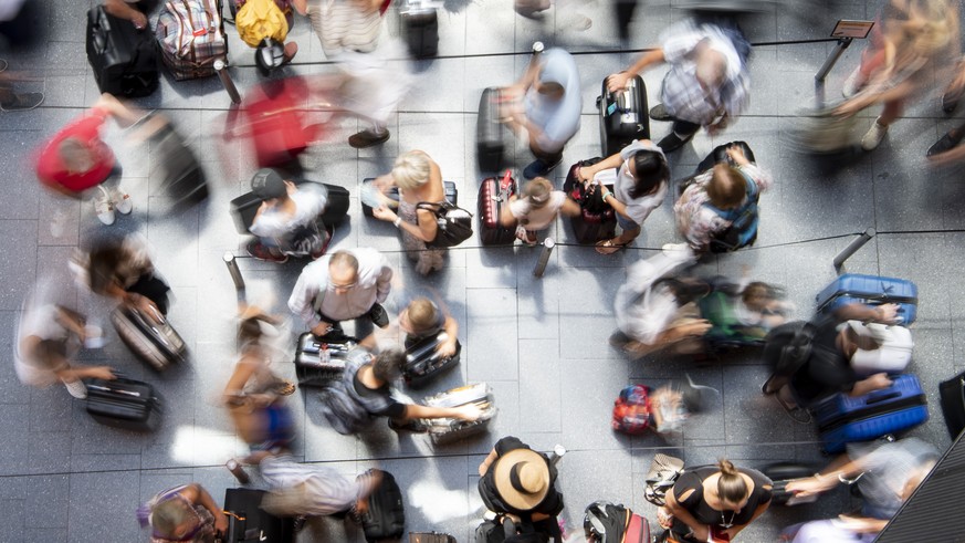 Fluggaeste schlaengeln sich um den Check-In Schalter auf dem Flughafen in Zuerich, aufgenommen am Sonntag, 15. Juli 2018. (KEYSTONE/Ennio Leanza)