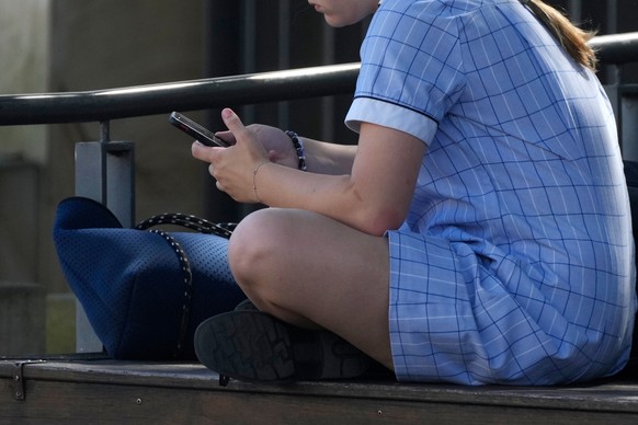 FILE - A young girl uses her phone while sitting on a bench in Sydney, on Nov. 8, 2024. (AP Photo/Rick Rycroft, File)
Australia Social Media