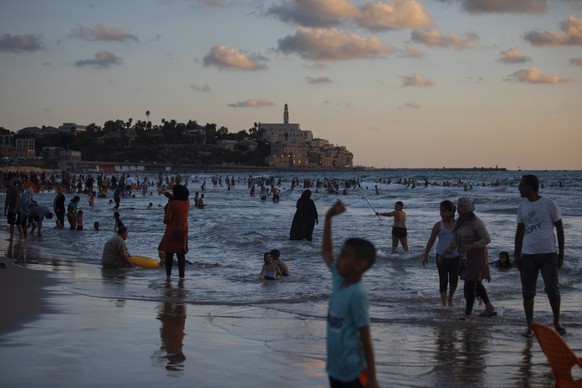Palestinians enjoy the day on the beach during the Eid Al Adha festival in Tel Aviv, Israel, Wednesday, July 21, 2021. The major Muslim holiday, at the end of the hajj pilgrimage to Mecca, is observed ...