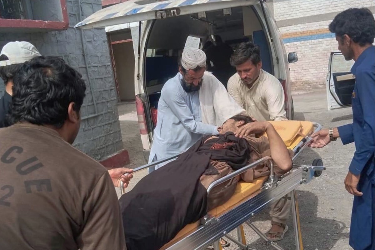 Rescue workers and volunteers transport an inured victim at a hospital after an overcrowded passenger bus plunged from a highway into a rocky ravine, in Dana Sar, a remote area near the border of Balo ...