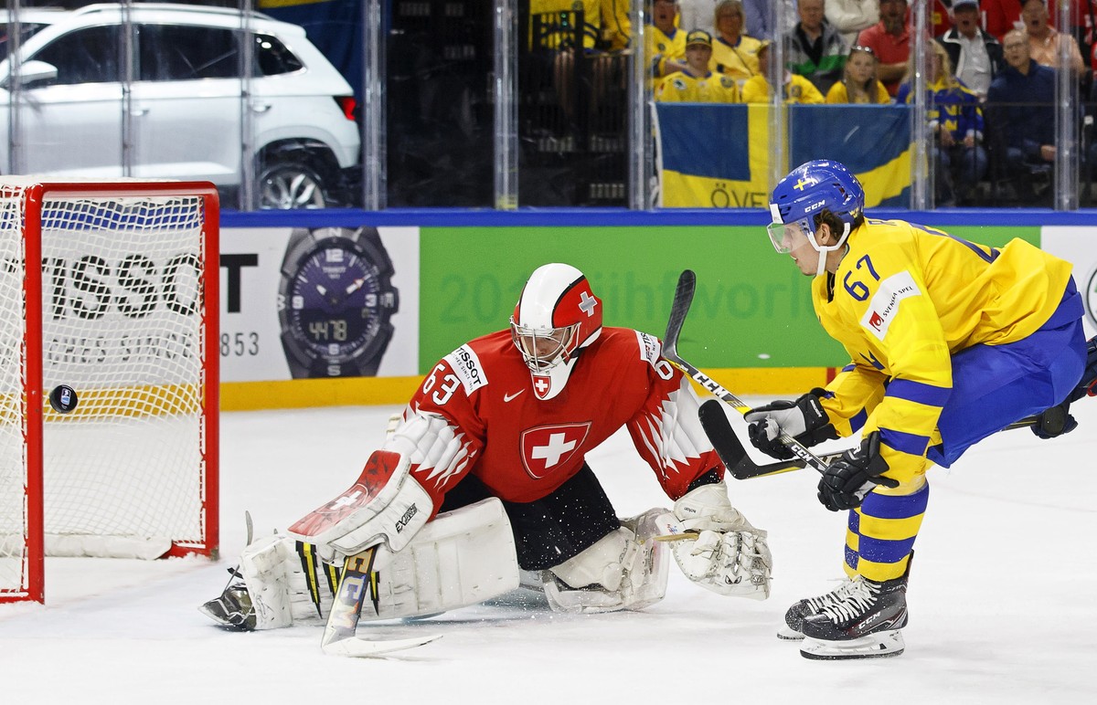 epa06733881 Sweden's forward Rickard Rakell (R) in action against Switzerland's goalie Leonardo Genoni (L) during the IIHF World Championship Group A ice hockey match between Switzerland and ...