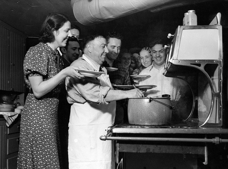 circa 1950: Father Lprinzi serves up spaghetti to his large family. (Photo by Evans/Three Lions/Getty Images)
