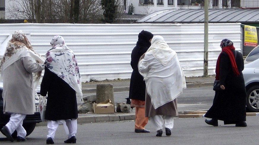 FILE - In this Feb. 7, 2013 file photo, women walk in the streets of Montfermeil, outside Paris. French Prime Minister Manuel Valls shocked many this week by referring to a &quot;territorial, social,  ...