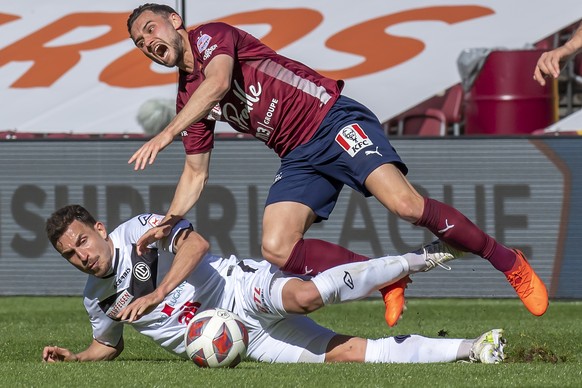 Le milieu luganais Olivier Custodio, gauche, lutte pour le ballon avec l&#039;attaquant genevois Alex Schalk, droite, lors de la rencontre de football de Super League entre le Geneve Servette FC et le ...