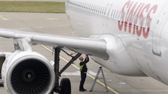 A maintenance staff member repares a hole in the Swiss International Airline plane that transports the athletes of the Swiss soccer national team the day after the UEFA EURO 2016 qualifying group E so ...