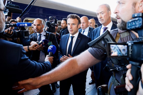 epa10015472 French President Emmanuel Macron (C) speaks to journalists as he arrives at the Kyiv railway station in Kyiv (Kiev), Ukraine, 16 June 2022. Macron, along with Italian Prime Minister Mario  ...