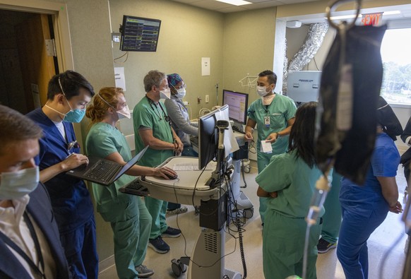 FILE - In this Tuesday, Aug. 10, 2021 file photo, Medical staff from multiple departments gather on the COVID ICU floor at Ochsner Medical Center in Jefferson, La. Louisiana hospitals already packed w ...