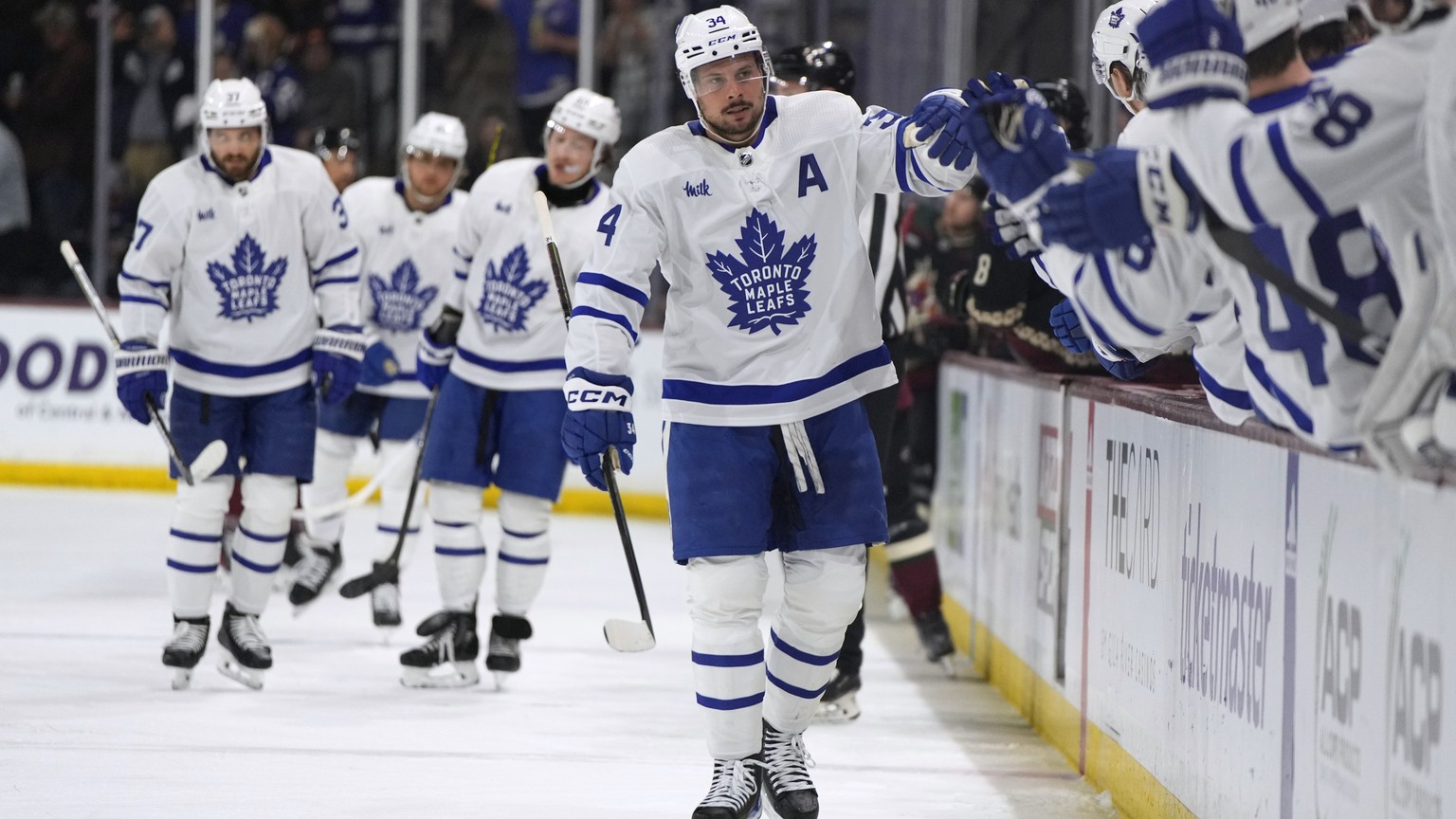 Toronto Maple Leafs center Auston Matthews (34) is congratulated after scoring his 50th goal of the season, against the Arizona Coyotes during the first period of an NHL hockey game Wednesday, Feb. 21 ...