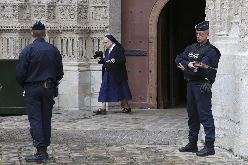 Armed French police stand guard as a nun leaves the Cathedral in Rouen after a funeral service in memory of slain French parish priest Father Jacques Hamel in Rouen, France, August 2, 2016. Father Jac ...