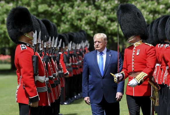 U.S President Donald Trump inspects an honour guard during a welcome ceremony in the garden of Buckingham Palace, in London, Monday, June 3, 2019, on the first day of a three day state visit to Britai ...