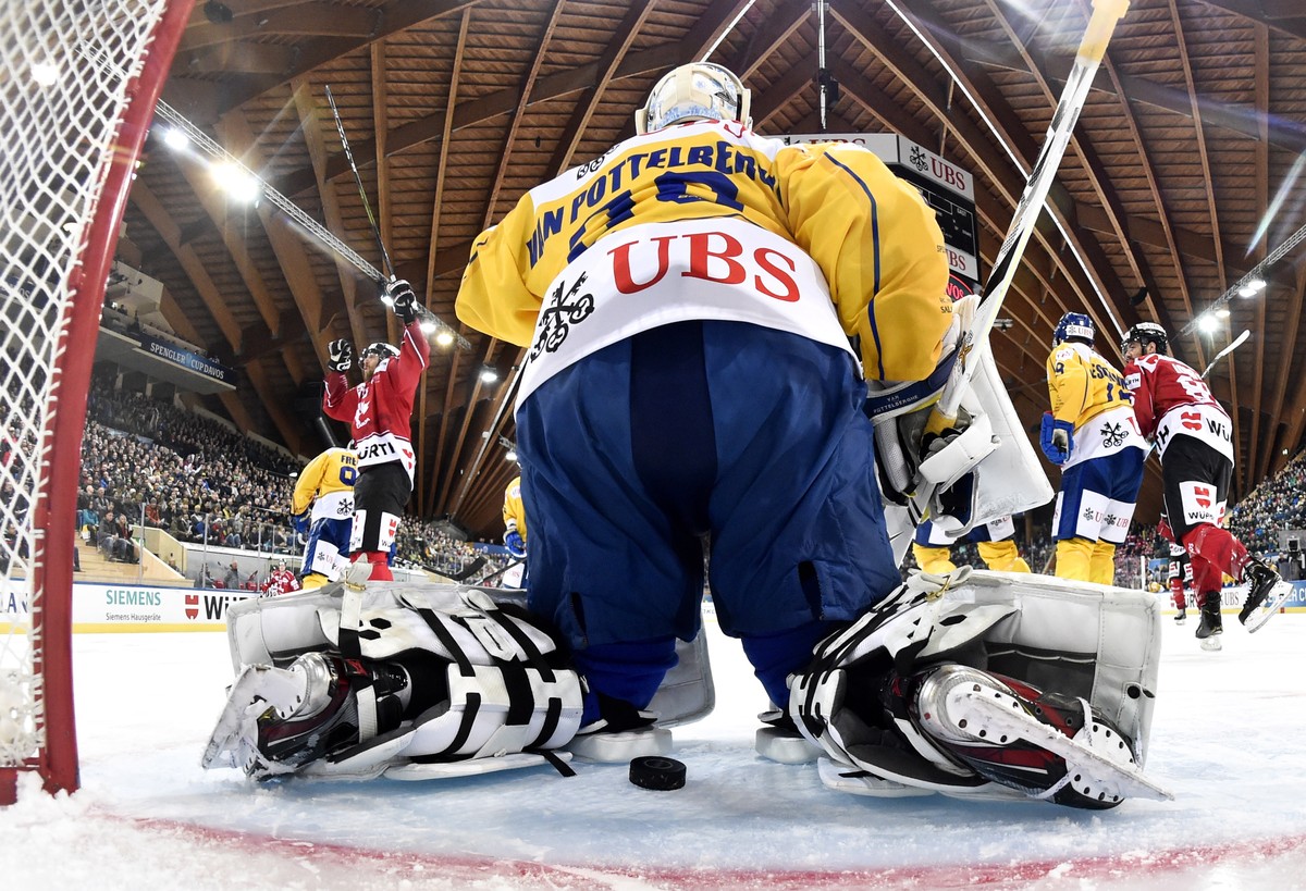 epa08093299 Team Canada`s Eric Fehr (L) celebrates scoring the 3-0 lead versus Davos' goalie Joren van Pottelberghe during the game between Team Canada and HC Davos, at the 93th Spengler Cup ice  ...
