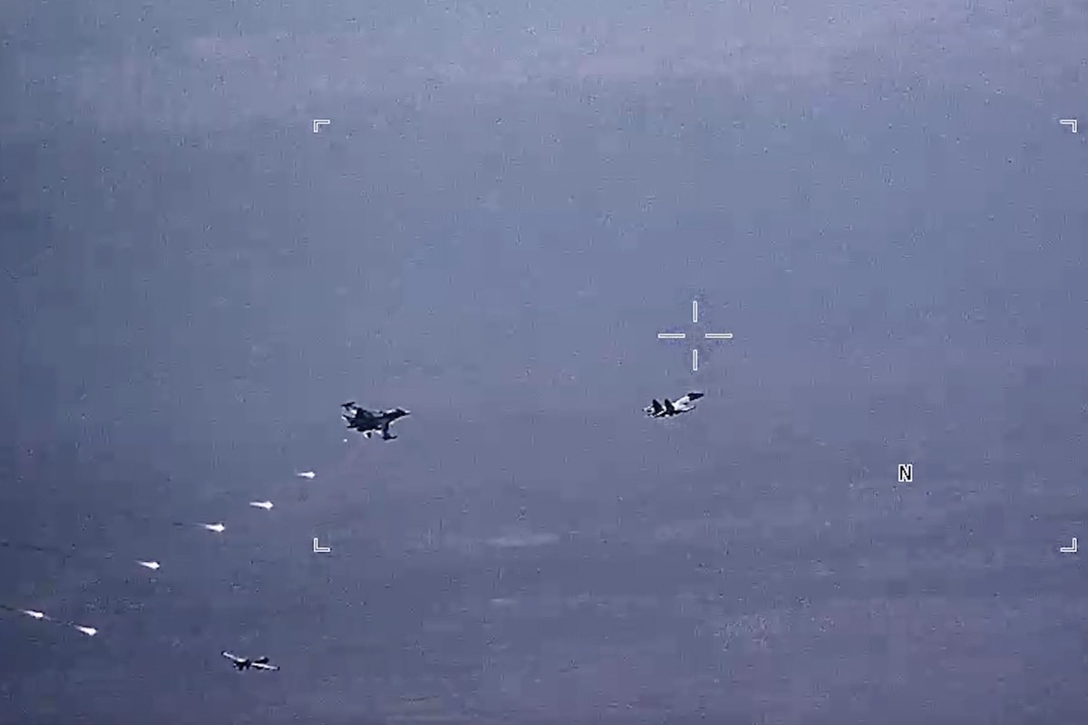 Des avions militaires russes lancent des fusées éclairantes sur un drone de l'armée de l'air américaine.