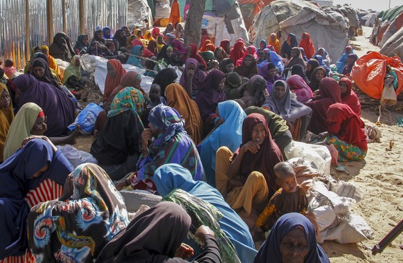 FILE - Somalis who fled drought-stricken areas sit at a makeshift camp on the outskirts of the capital Mogadishu, Somalia on Feb. 4, 2022. Two U.N. food agencies issued stark warnings on Monday, June  ...