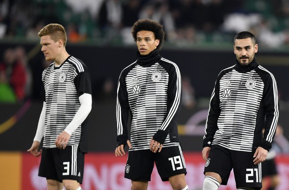 Germany's Marcel Halstenberg, left, Leroy Sane, center, and Ilkay Gundogan stand during warm up prior to a international friendly soccer match between Germany and Serbia at the Volkswagen Arena s ...