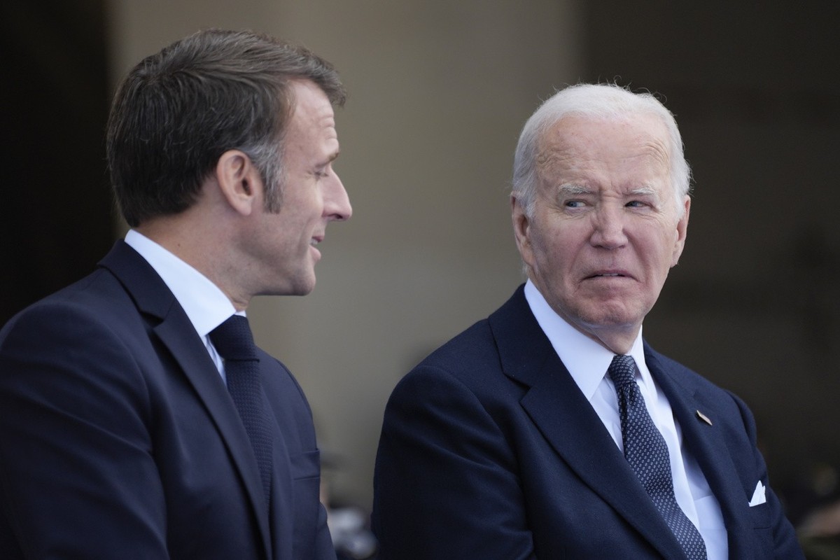 President Joe Biden and French President Emmanuel Macron, talk during ceremonies to mark the 80th anniversary of D-Day, Thursday, June 6, 2024, in Normandy. (AP Photo/Evan Vucci)