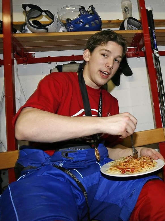 ZSC Lions defensman Patrick Geering, left, and forward Philippe Schelling, right, eat some spaghetti in the locker room after ZSC&#039;s victory in the ice hockey Champions League second leg final gam ...