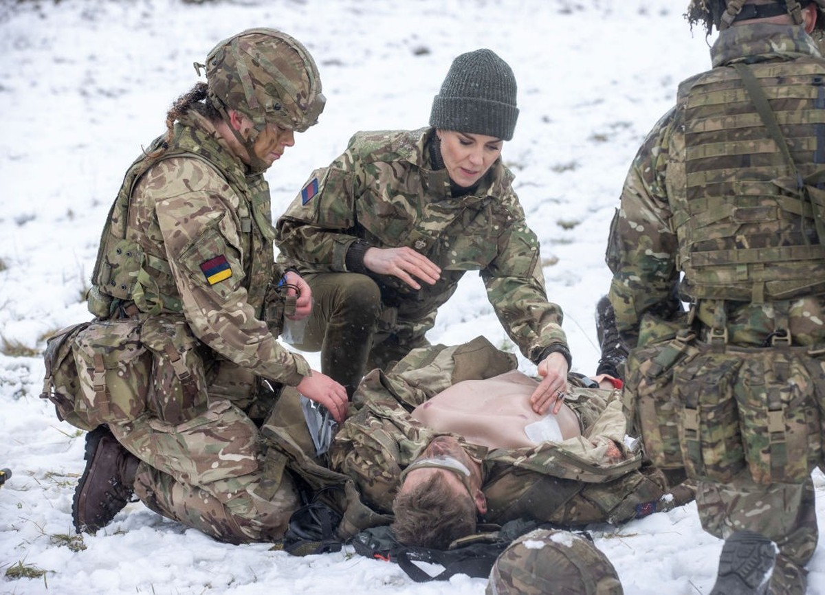 SALISBURY, ENGLAND - MARCH 08: Catherine, Princess of Wales assists L/Cpl Jodie Newell tend to a "wounded soldier" in an exercise, during her visit to the Irish Guards on Salisbury Plain, on ...