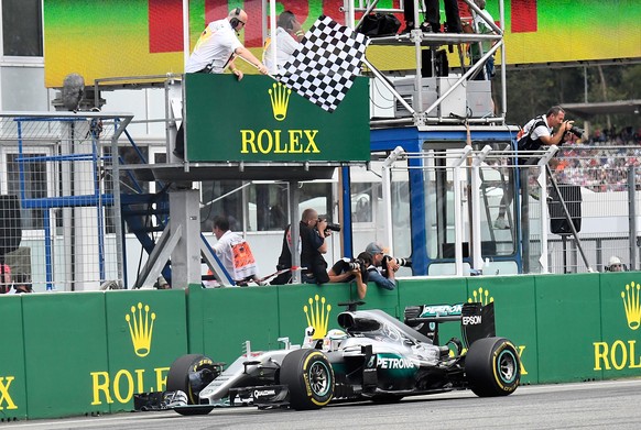 Mercedes driver Lewis Hamilton of Britain gets the checkered flag as he crosses the finish line to win the German Formula One Grand Prix in Hockenheim, Germany, Sunday, July 31, 2016. (AP Photo/Jens M ...