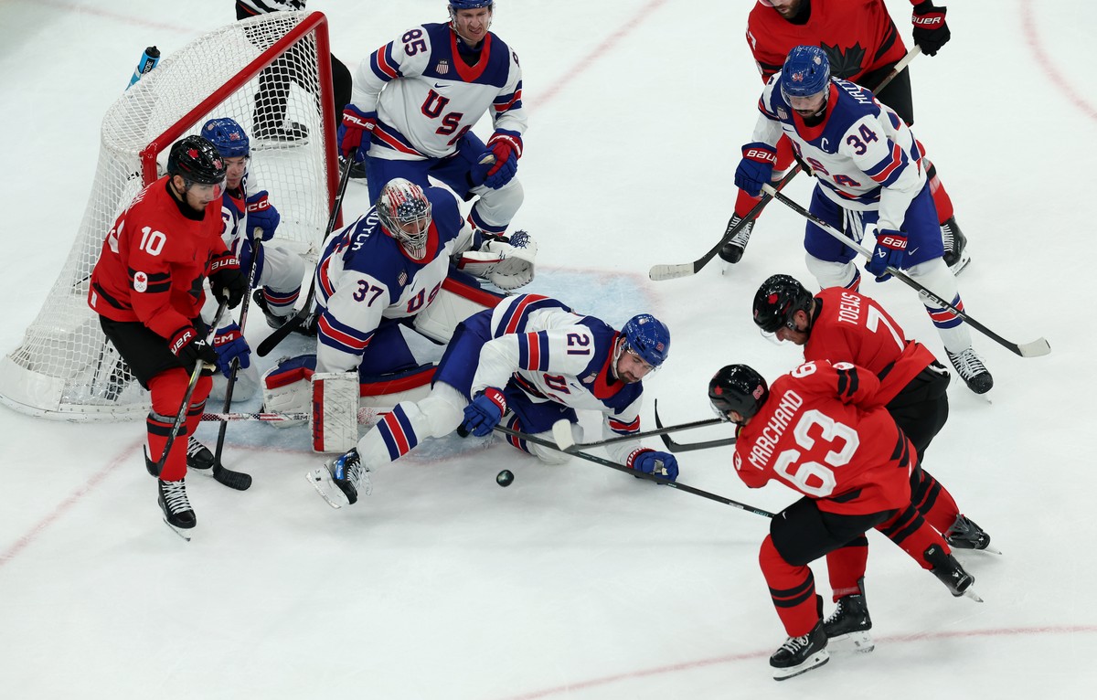 epa12768682 Brad Marchand of Canad attacks the goal of US goaltender Connor Hellebuyck during the Men's Ice Hockey final match between Canada and the USA at the Milano Cortina 2026 Winter Olympic ...
