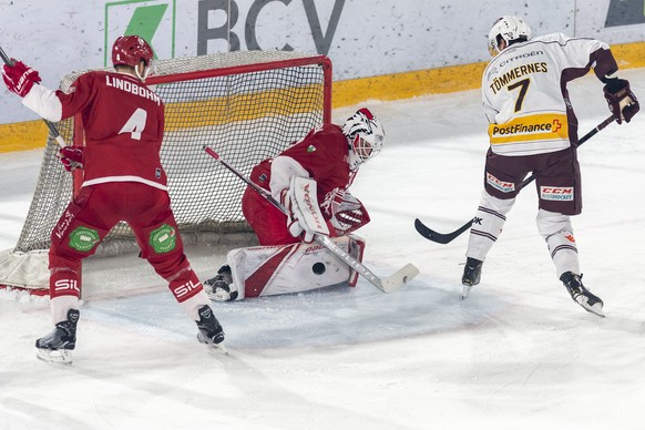 Le joueur lausannois, Petteri Lindbohm, gauche, lutte pour le puck avec le joueur genevois, Henrik Toemmernes, droite, devant le gardien lausannois, Sandro Zurkirchen, centre, lors du match du champio ...