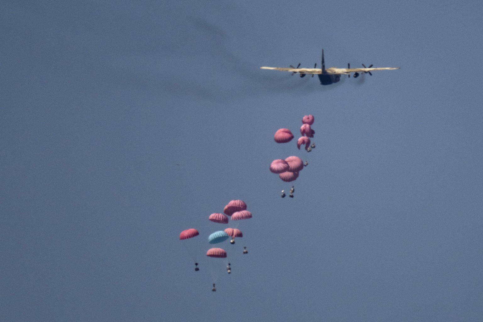 An aircraft airdrops humanitarian aid over northern Gaza Strip, as seen from southern Israel, Wednesday, March 20, 2024. (AP Photo/Leo Correa)