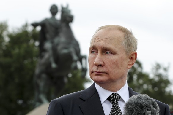 Russian President Vladimir Putin delivers his speech standing in front of the equestrian statue of Peter the Great, prior to the military parade during Navy Day celebrations, on the Neva River, in St. ...