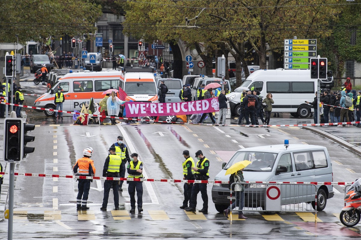 Menschen der Klimaorganisation "Extinction Rebellion" blockieren die Strasse in der Zuercher Innenstadt, aufgenommen am Dienstag, 5. Oktober 2021 in Zuerich. (KEYSTONE/Ennio Leanza)