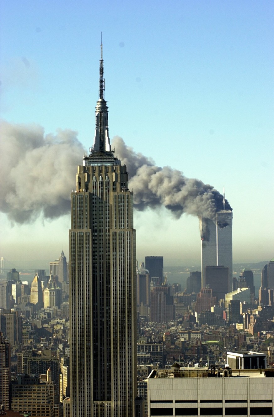 Plumes of smoke pour from the World Trade Center buildings in New York Tuesday, September 11, 2001. Planes crashed into the upper floors of both World Trade Center towers minutes apart Tuesday in a ho ...