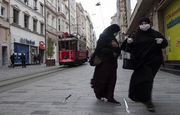 epa08324500 People with face masks walk at Istiklal Street as the city is almost deserted over coronavirus concerns, in Istanbul, Turkey, 26 March 2020. Turkish Health Minister Koca said on 25 March t ...