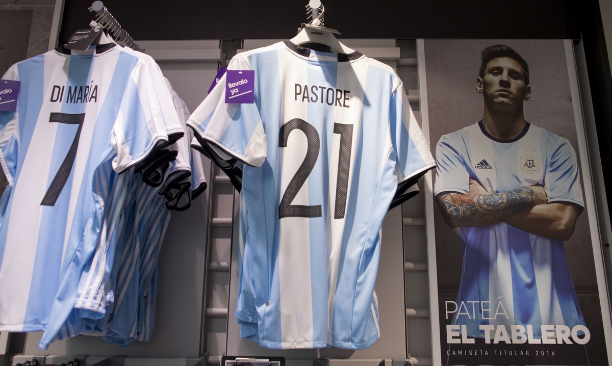A publicity poster of Argentine soccer star Lionel Messi reading in Spanish "kick the board" which means "rip it up and start over" is seen beside Argentina national team jerseys w ...
