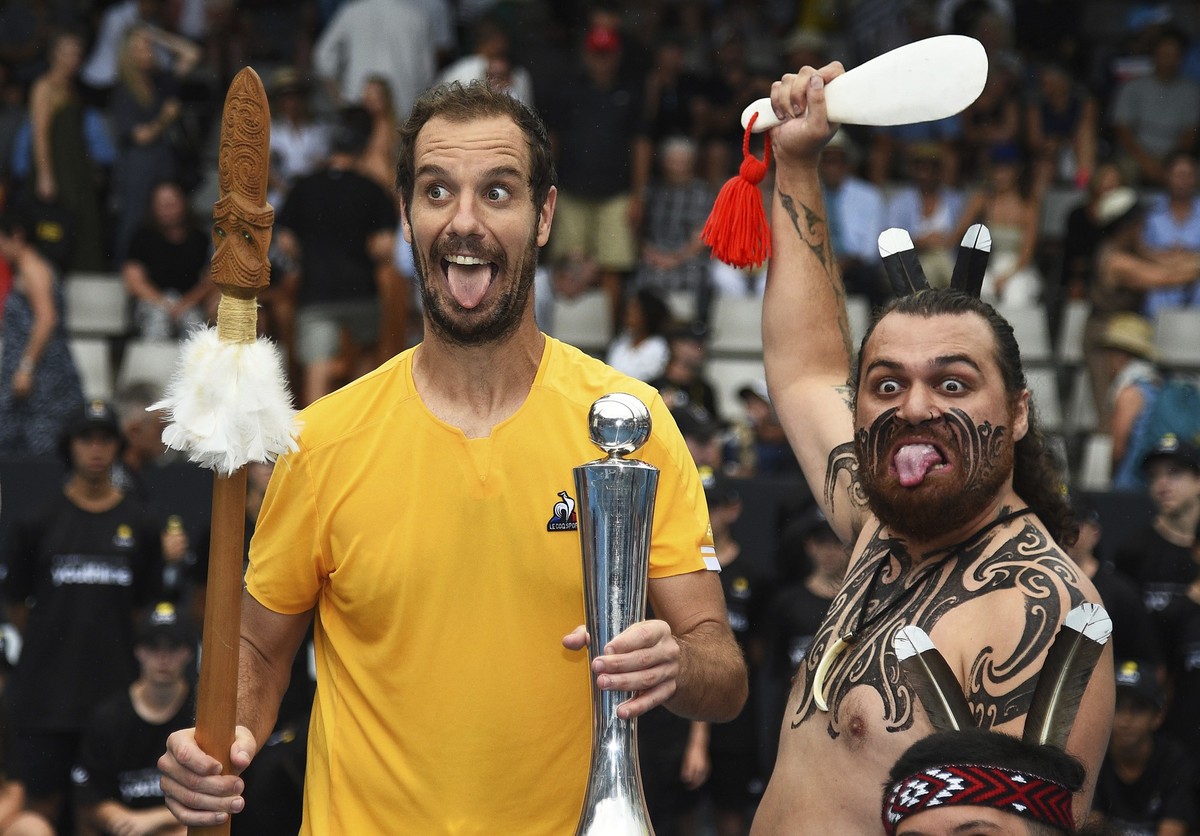 Richard Gasquet of France poses with the trophy with a local Maori perfomer after winning the men's singles final over Cameron Norrie of Britain at the ASB Classic tennis event in Auckland, New Z ...