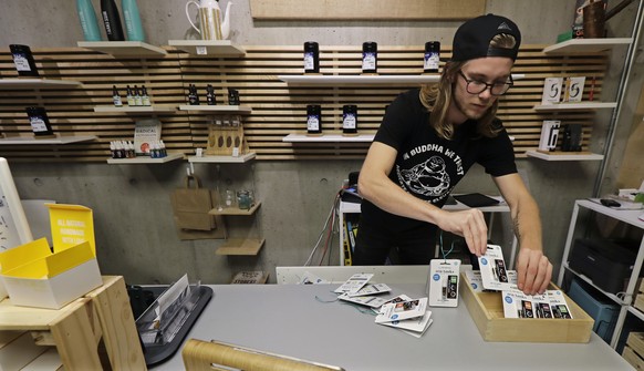 In this Sept. 25, 2018 photo, Peter Backlund, an employee at the Village Bloomery medical cannabis dispensary in Vancouver, British Columbia, organizes a display. On Oct. 17, 2018, Canada will become  ...