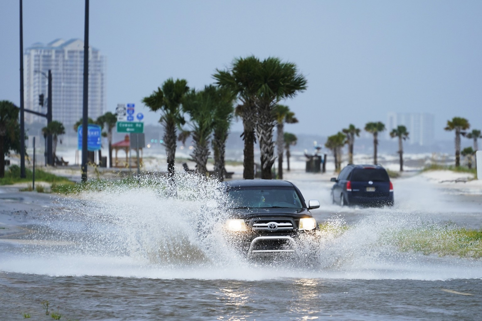 Cars drive through flood waters along route 90 as outer bands of Hurricane Ida arrive Sunday, Aug. 29, 2021, in Gulfport, Miss. (AP Photo/Steve Helber)
