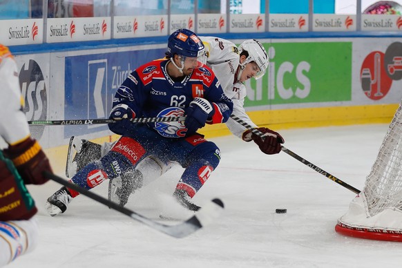 Servettes Giancarlo Chanton, links, kaempft um den Puck gegen ZSC Denis Malgin, rechts, im Eishockeyspiel der National League zwischen den ZSC Lions und Geneve-Servette HC am Sonntag, 22. Oktober 2023 ...
