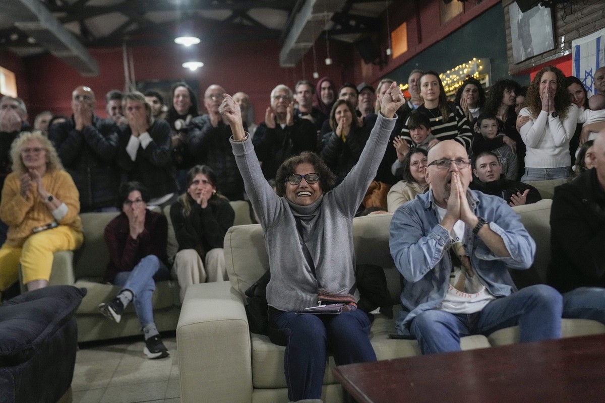 Friends and relatives of Ohad Ben Ami and Eli Sharabi, who were taken from kibbutz Beeri on Oct.7, 2023 attack, react as they watch the live broadcast of their release from Hamas captivity in Gaza, at ...