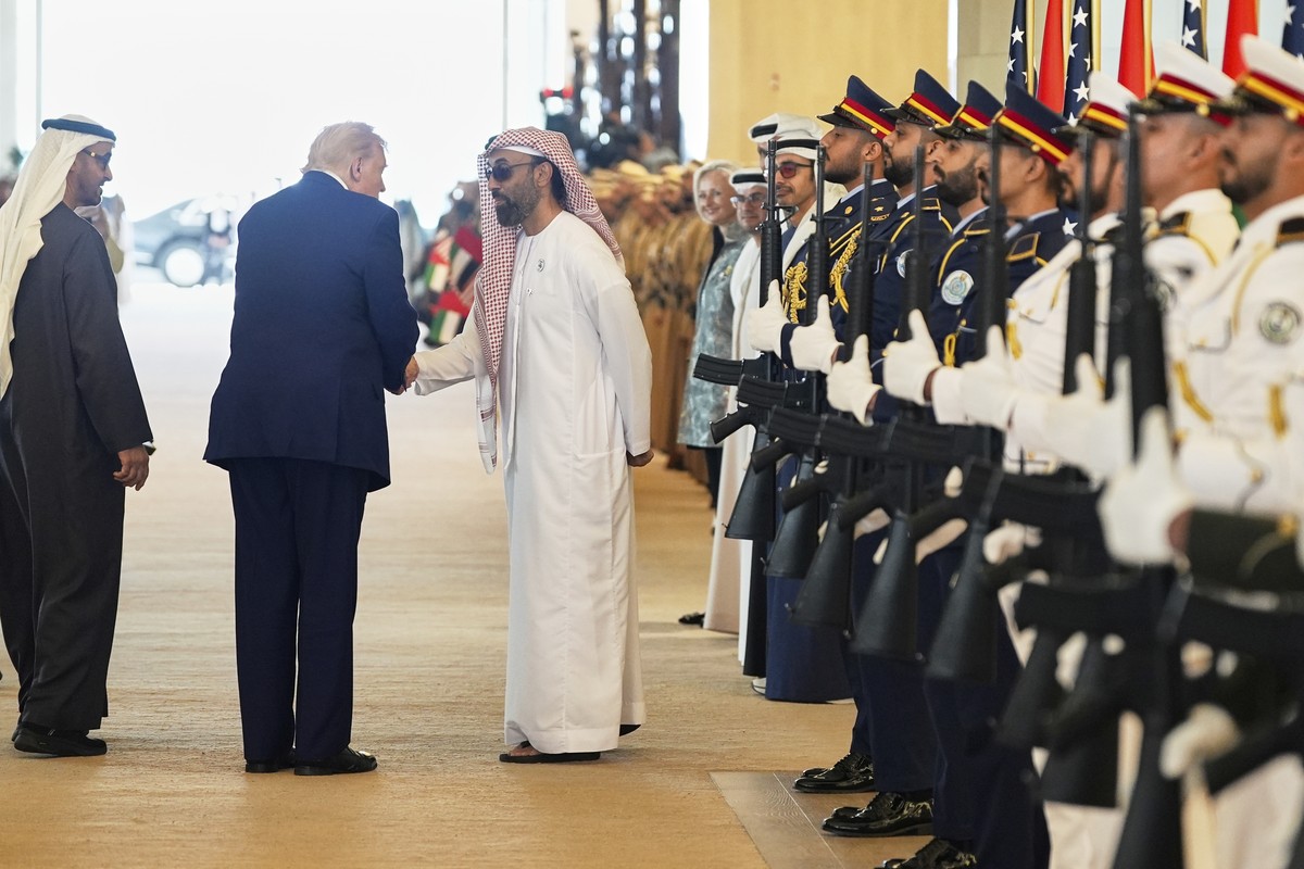 President Donald Trump shakes hands with Tahnoun bin Zayed Al Nahyan, National Security Advisor of UAE, next to UAE President Mohammed bin Zayed Al Nahyan, left, after arriving on Air Force One at Abu ...