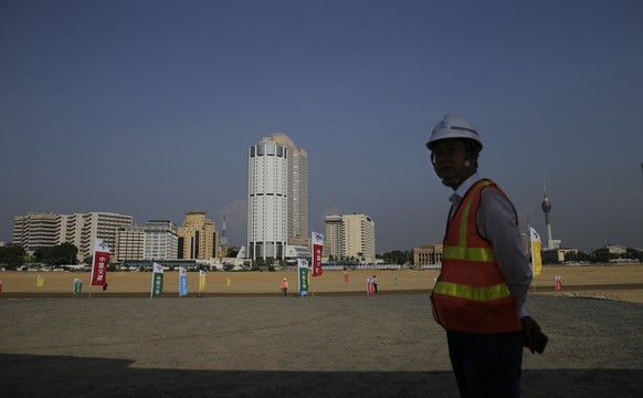 Ein chinesischer Bauarbeiter steht vor einem neuen Hafengebäude in Colombo, der Hauptstadt von Sri Lanka.
